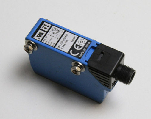 Sensor fotoeléctrico compacto SICK W250-2P2431 con luz roja visible y número de pieza 6044699